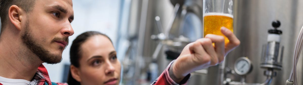 Man looking at beer in glass